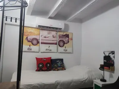 a bedroom with a bed with a poster of a car at La Casita de Cullera in Cullera