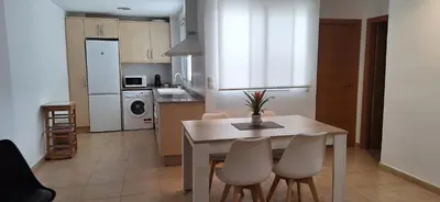 a kitchen with a table and chairs and a kitchen with a table and a kitchen at Apartamento Cervantes in Benetúser