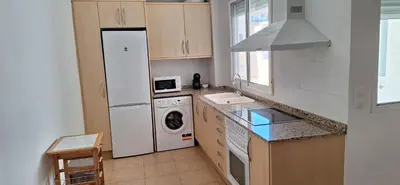 a kitchen with a refrigerator and a washing machine at Apartamento Cervantes in Benetúser