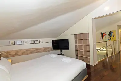 a bedroom with a white bed and a flat screen tv at GuestReady - Charming place in Valencia in Valencia