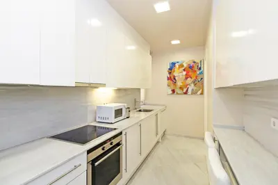 a kitchen with white cabinets and a microwave at GuestReady - Charming place in Valencia in Valencia