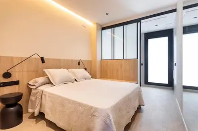 a bedroom with a large bed in a room with windows at Lujoso apartamento en Ruzafa in Valencia