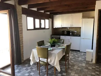 a kitchen with a table with chairs and a white refrigerator at Penthouse with two terraces near the sea in Valencia