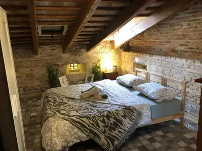 a bedroom with a bed in a brick wall at Beautiful penthouse with two terraces near the sea in Valencia