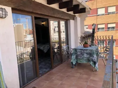 a patio with a table and chairs on a balcony at Beautiful penthouse with two terraces near the sea in Valencia