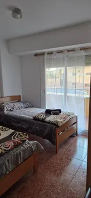 two beds sitting in a room with a window at A fantastic apartment on the beach in Canet de Berenguer