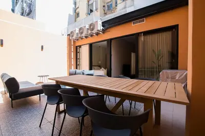 a dining room with a wooden table and chairs at Apartamento moderno con terraza en el centro in Valencia