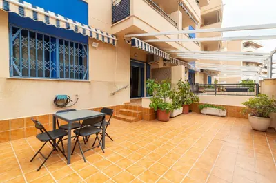 a courtyard with a table and chairs in a building at Global Vacacional, Planta baja en Canet de Berenguer in Canet de Berenguer