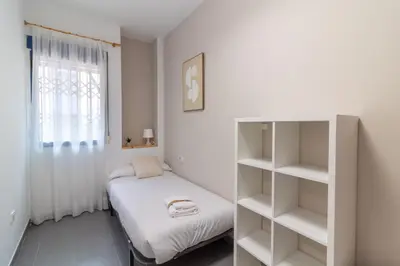 a small bedroom with a bed and a book shelf at Global Vacacional, Planta baja en Canet de Berenguer in Canet de Berenguer