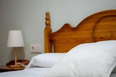 a bedroom with a bed with a wooden headboard and a lamp at Global Vacacional, Planta baja en Canet de Berenguer in Canet de Berenguer