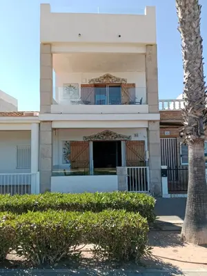 a building with a palm tree in front of it at Els Vents primera línea playa Puçol in Puzol