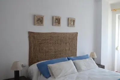 a bedroom with a bed with three pictures on the wall at Els Vents primera línea playa Puçol in Puzol