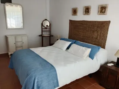 a bedroom with a large bed with blue and white sheets at Els Vents primera línea playa Puçol in Puzol