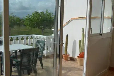 a patio with a table and chairs on a balcony at Els Vents primera línea playa Puçol in Puzol