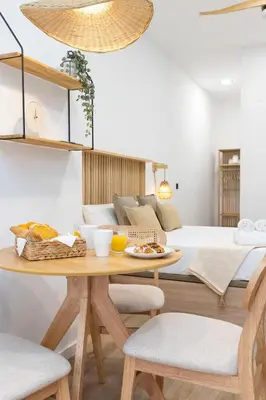 a living room with a table and a bed at Travel Habitat Nou Mestalla Suites in Valencia
