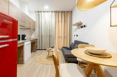 a kitchen and living room with a red refrigerator and a table at Travel Habitat Nou Mestalla Suites in Valencia