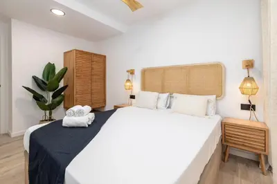 a bedroom with a large white bed and a plant at Travel Habitat - Apartamento Familiar & Espacioso de 3 Dormitorios in Valencia