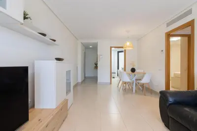 a living room with a couch and a table at Apartamento con Vistas al mar, Piscina y Pista de Paddle in Valencia