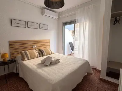 a bedroom with a white bed with towels on it at VMC Rooms in Tavernes de Valldigna