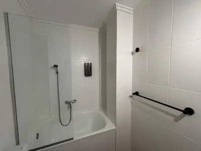 a white bathroom with a shower and a tub at VMC Rooms in Tavernes de Valldigna
