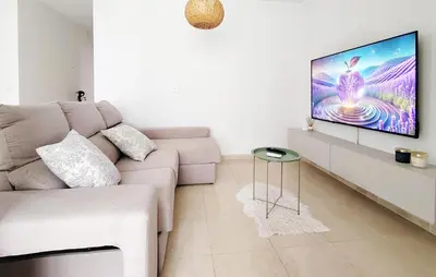 a living room with a white couch and a tv at Pet Friendly Home In Puerto De Sagunto in Puerto de Sagunto
