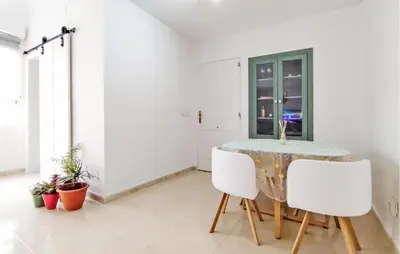 a dining room with a table and two white chairs at Pet Friendly Home In Puerto De Sagunto in Puerto de Sagunto