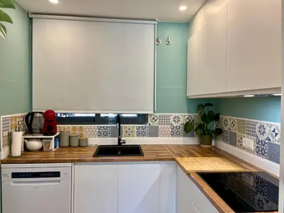 a kitchen with white cabinets and a sink at Casa Hoyo 19 in Masía Aldamar