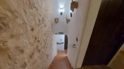 a hallway with a staircase with a stone wall at Las Anas Rural in Cortez de Pallas