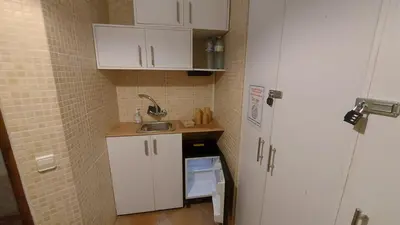 a small kitchen with white cabinets and a sink at Las Anas Rural in Cortez de Pallas