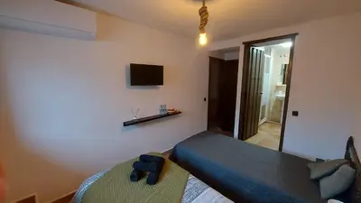 a bedroom with a bed and a tv on the wall at Las Anas Rural in Cortez de Pallas