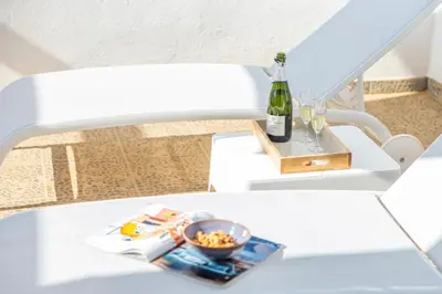 a bottle of wine and a bowl of food on a white bench at Valencia Beach Luxury Penthouse, Late Checkout in Valencia