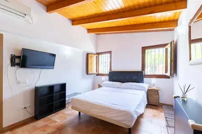 a bedroom with a bed and a flat screen tv at Chalet Barraca d 'Aigües Vives in Barraca de Aguas Vivas