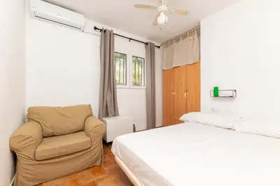 a bedroom with a bed and a chair at Chalet Barraca d 'Aigües Vives in Barraca de Aguas Vivas