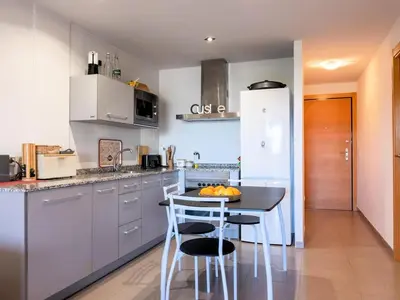 a kitchen with a table and some chairs in it at Winahost Apartment Neo Residencial Mediterráneo in Barrio-Mar