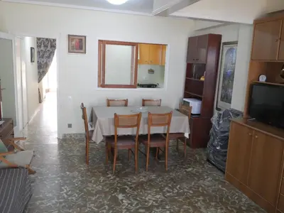 a dining room with a table and chairs and a television at Levante, 1-N in Cullera