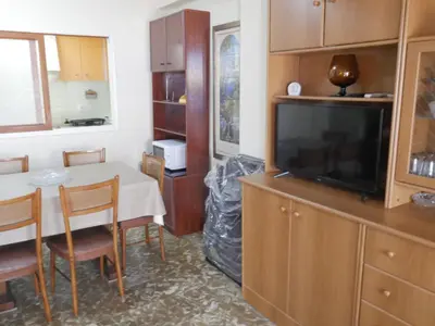 a kitchen with a table and a tv and a dining room at Levante, 1-N in Cullera