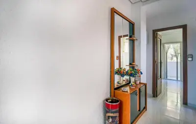 a hallway with a mirror and a dresser with flowers at 2 Bedroom Lovely Apartment In Sagunto in Sagunto