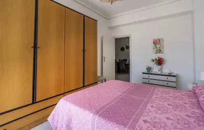 a bedroom with a pink bed and wooden cabinets at 2 Bedroom Lovely Apartment In Sagunto in Sagunto