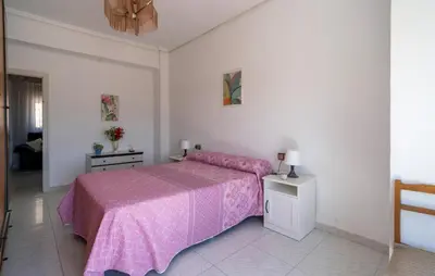 a bedroom with a bed with a pink bedspread at 2 Bedroom Lovely Apartment In Sagunto in Sagunto