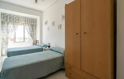 a bedroom with two beds and a cabinet at 2 Bedroom Lovely Apartment In Sagunto in Sagunto