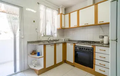 a kitchen with wooden cabinets and a black oven at 2 Bedroom Lovely Apartment In Sagunto in Sagunto