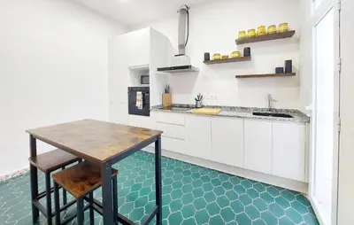 a kitchen with white cabinets and a wooden table at Gorgeous Home In Llaurí With Wifi in Llaurí