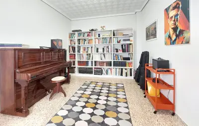 a living room with a piano and a book shelf at Gorgeous Home In Llaurí With Wifi in Llaurí