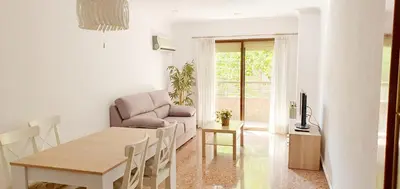 a white living room with a table and a couch at Valencia verano in Valencia