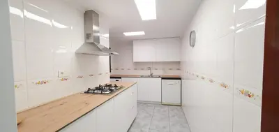 a kitchen with white cabinets and a wooden counter top at Valencia verano in Valencia