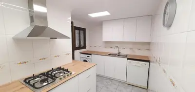 a kitchen with white cabinets and a stove top oven at Valencia verano in Valencia