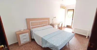 a bedroom with a bed and a desk and a piano at Valencia verano in Valencia