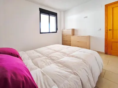 a white bed in a room with a window at Apartamento con Terraza junto al Mar en Moncofa in Moncófar
