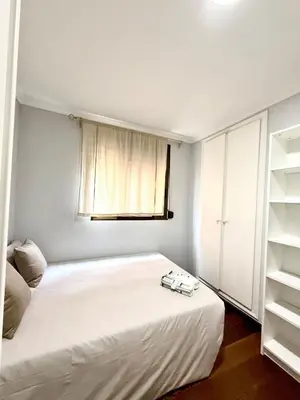 a bedroom with a white bed and a window at Apartment 100m from the beach in Cullera