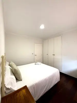 a bedroom with a large white bed and white cabinets at Apartment 100m from the beach in Cullera